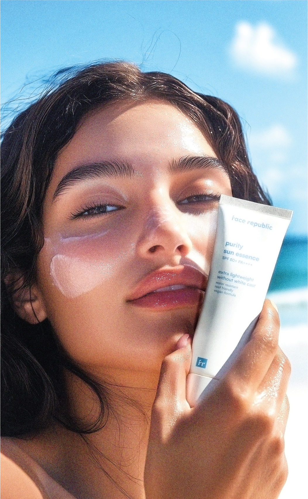 Woman with Face Republic Purity Sun Essence against a blue sky
